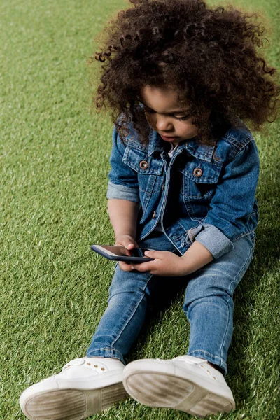 Curly girl resting on lawn — Stock Photo, Image
