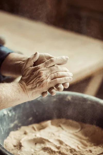 Крупним планом чоловічі гончарні руки беруть глину з миски — стокове фото