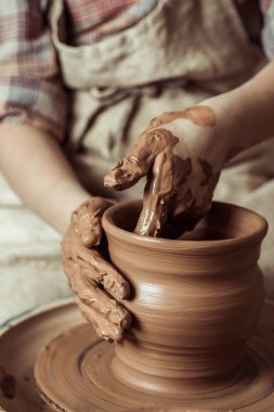 Close up of child hands working on pottery wheel at workshop clipart