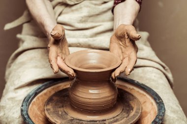 Close up of female hands working on potters wheel clipart