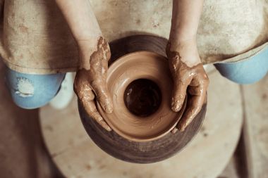 Close up of child hands working on pottery wheel at workshop clipart