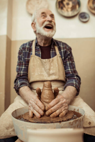 Front view of male craftsman working on potters wheel