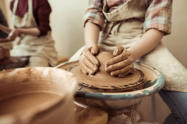 Close up of child hands working on pottery wheel at workshop — Stock Photo, Image