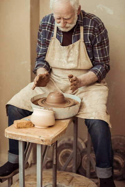 Front view of male craftsman working on potters wheel
