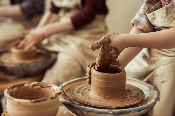 Close up of child hands working on pottery wheel at workshop — Stock Photo, Image