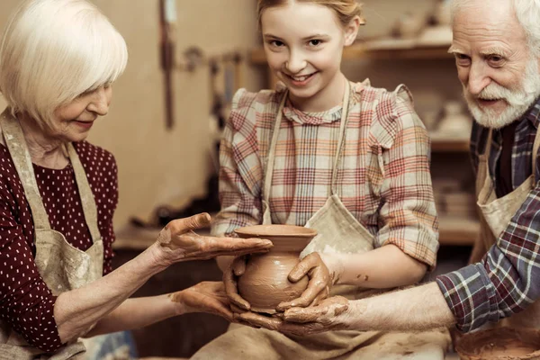 Babička a děda s vnučkou tvorba keramiky v dílně — Stock fotografie