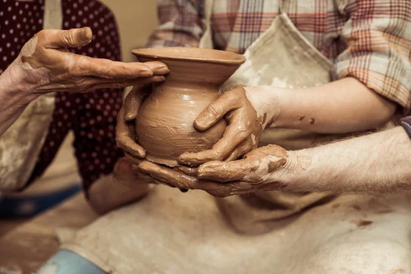 Bijgesneden afbeelding van oma en opa met kleindochter maken van aardewerk op workshop — Stockfoto