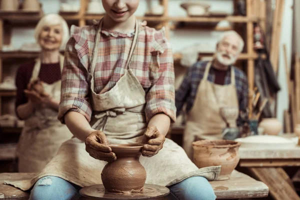 Avó e avô com neta fazendo cerâmica na oficina — Fotografia de Stock