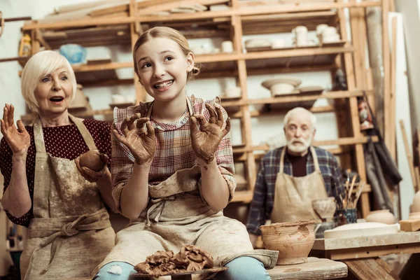 Abuela y abuelo con nieta haciendo cerámica en el taller — Foto de Stock