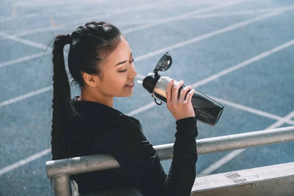 Asian sportswoman drinking water — Stock Photo, Image