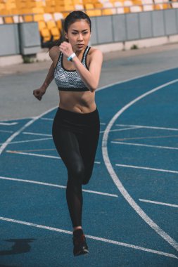 sportswoman training on running track clipart