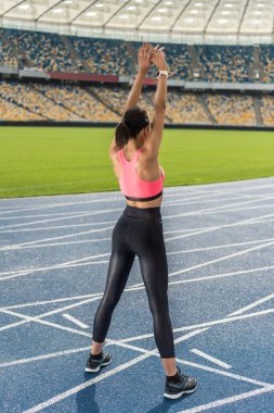Sportswoman exercising on stadium  clipart