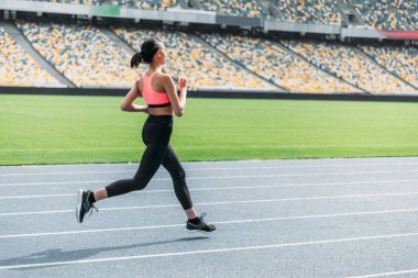 Sportswoman running on stadium  clipart