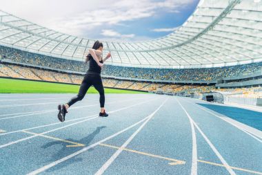 Sportswoman running on stadium  clipart