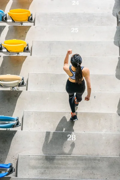 Sportlerin läuft auf Stadiontreppe — Stockfoto