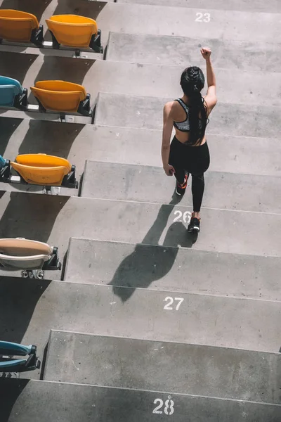 Sportlerin läuft auf Stadiontreppe — Stockfoto