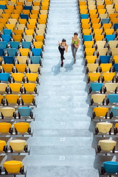 Sportswomen running on stadium stairs — Stock Photo, Image