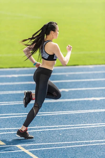 Sportvrouw training op de atletiekbaan — Stockfoto
