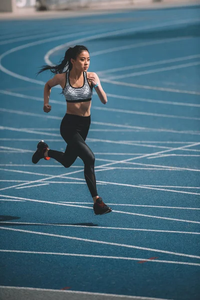 Sportlerin läuft auf Stadion zu — Stockfoto