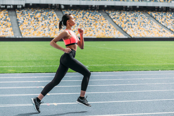 Спортсменка бегает по стадиону
 