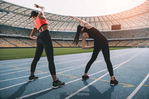 Sportswomen exercising on stadium — Stock Photo, Image