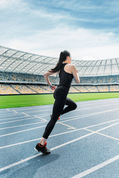 Sportswoman running on stadium 