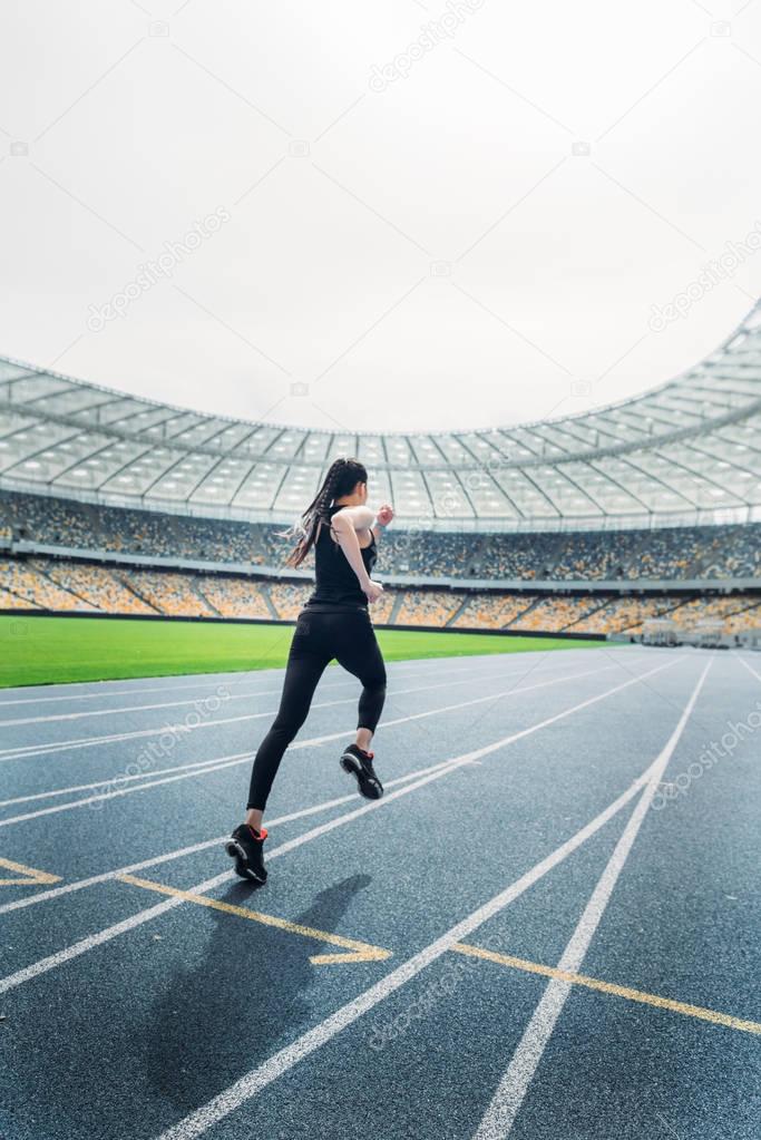 Sportswoman running on stadium 