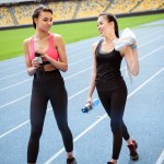 Sportswomen resting on stadium