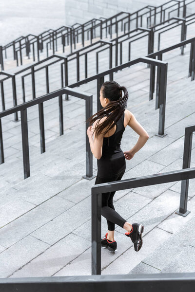 Sportswoman training on stadium stairs 