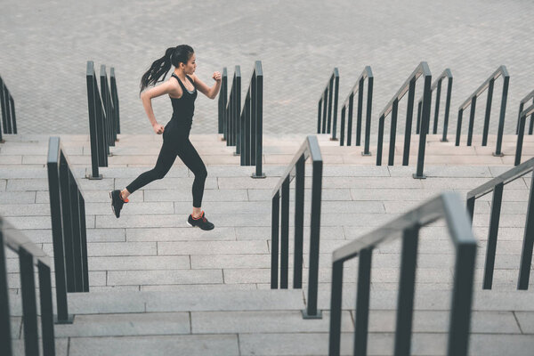 Sportswoman training on stadium stairs 