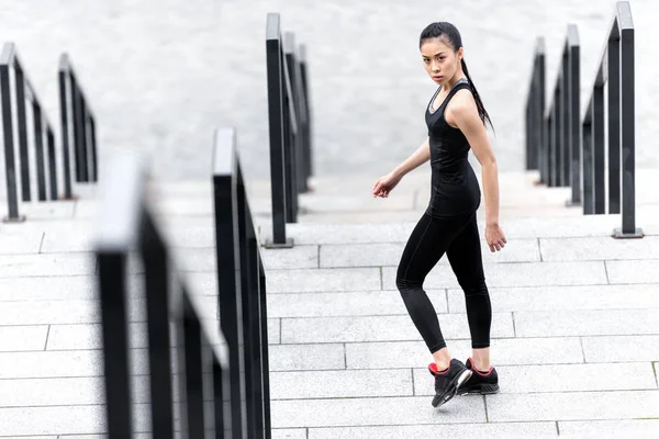 Sportvrouw training op de trappen van het stadion — Stockfoto