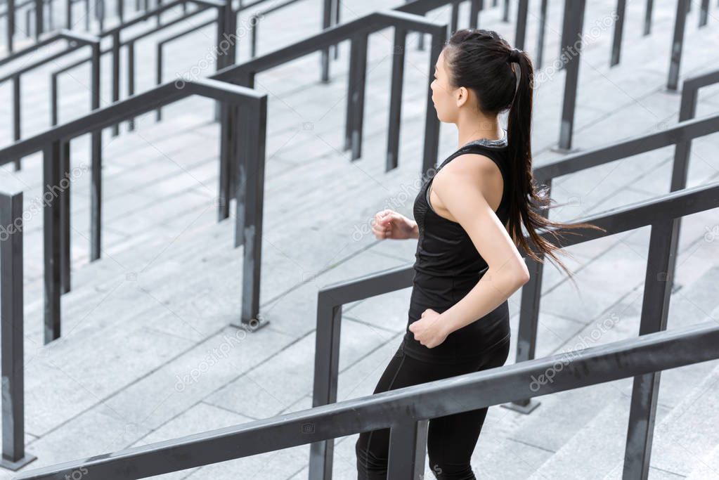 Sportswoman training on stadium stairs 
