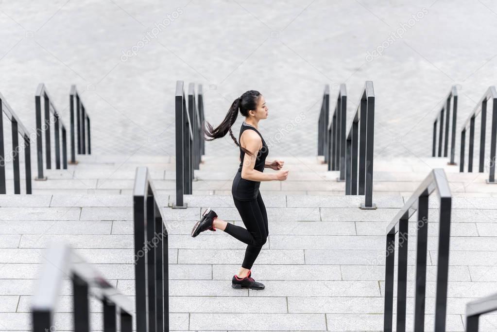 Sportswoman training on stadium stairs 