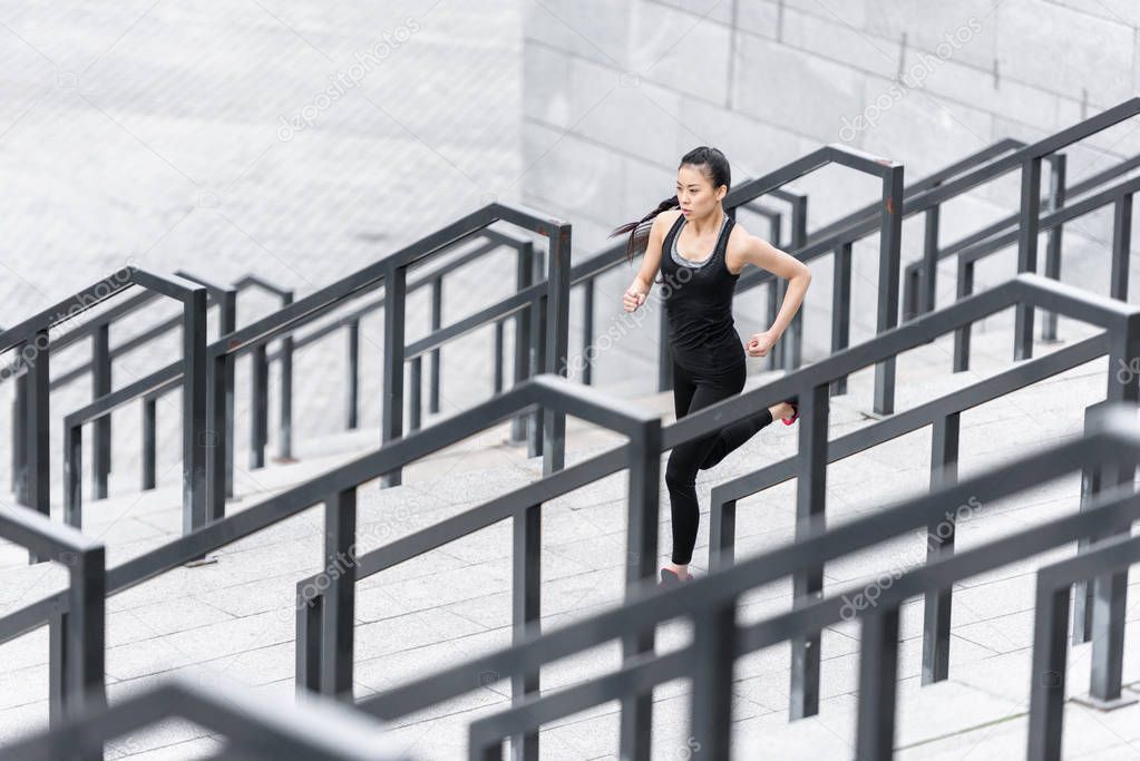 Sportswoman training on stadium stairs 