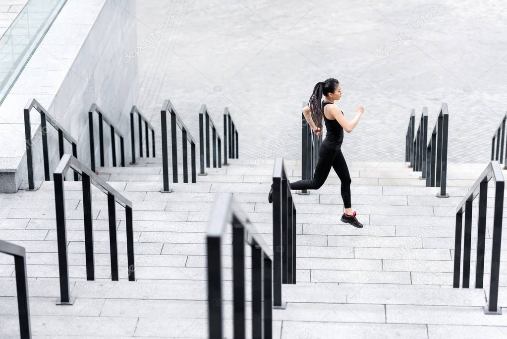 Sportswoman training on stadium stairs 