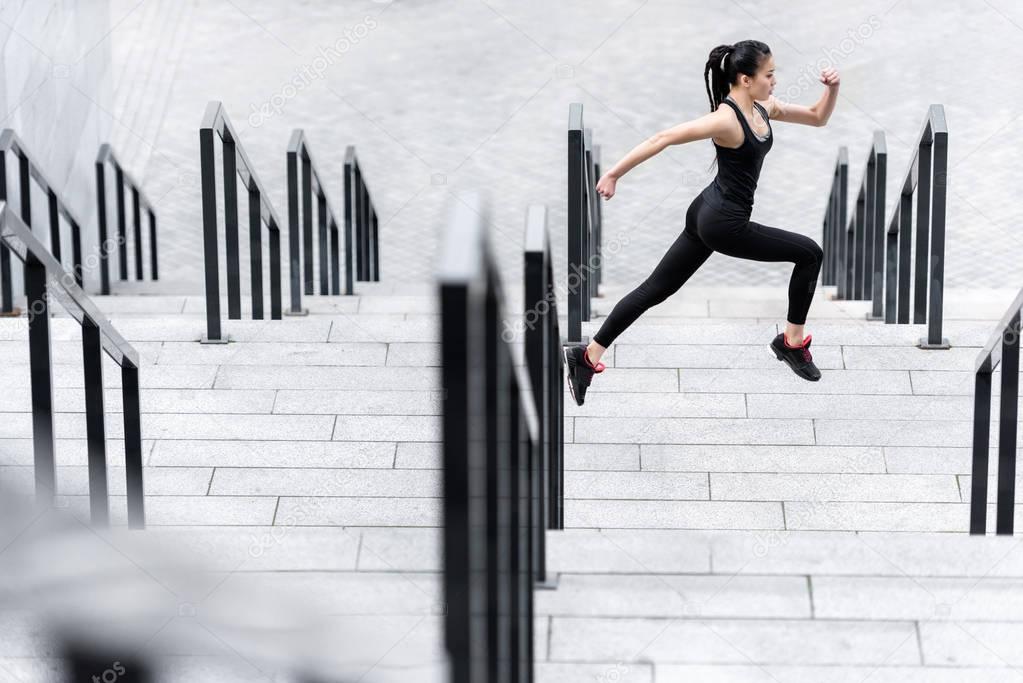 Sportswoman training on stadium stairs 