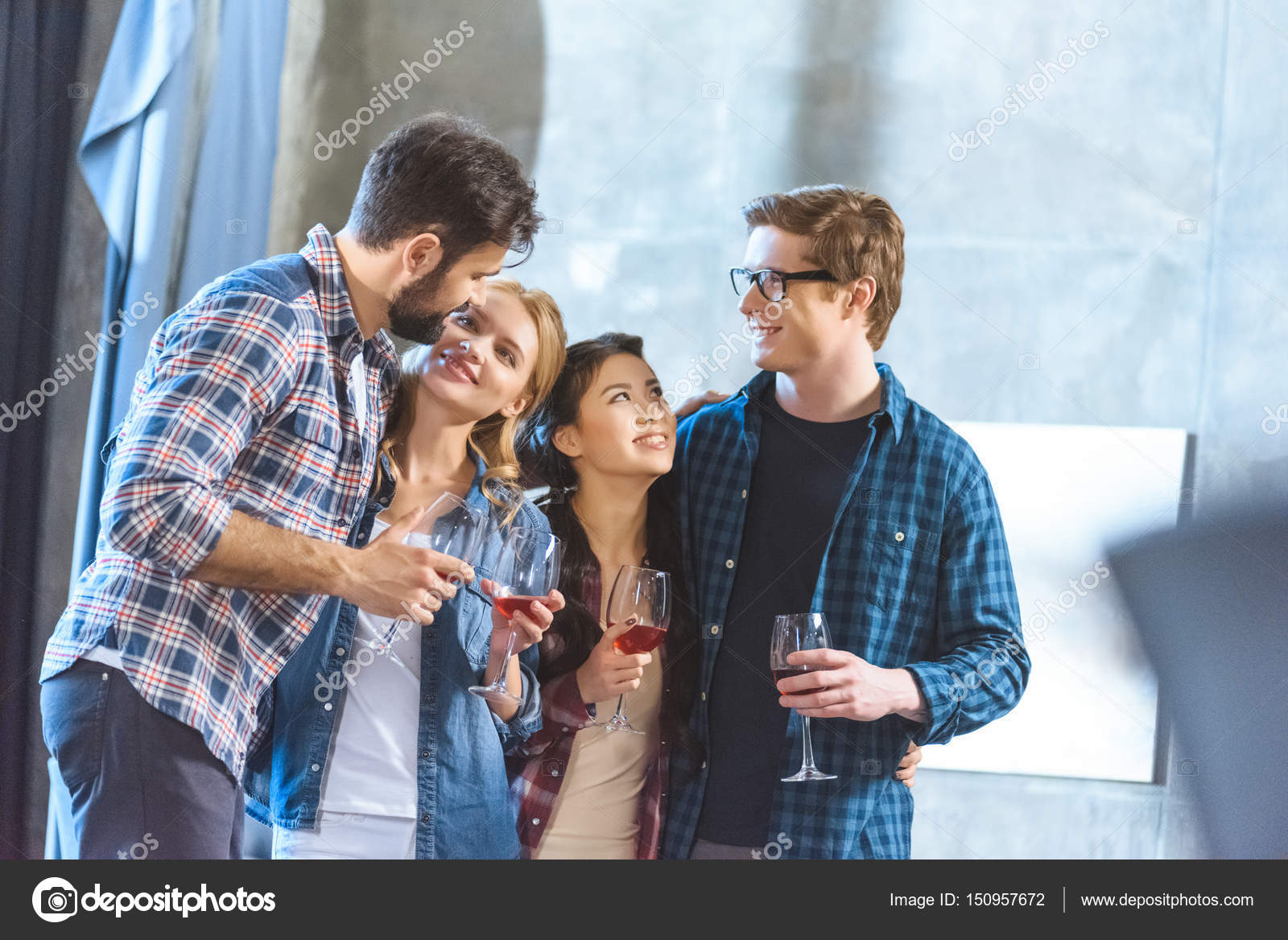 Young friends drinking wine Stock Photo by ©ArturVerkhovetskiy 150957672