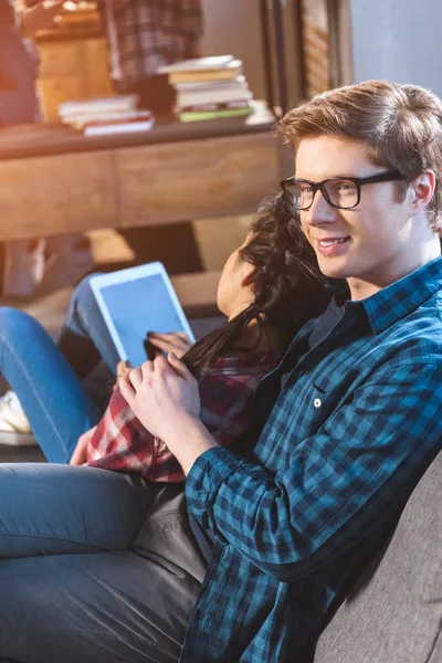 Pareja descansando en el sofá, utilizando la tableta — Foto de Stock