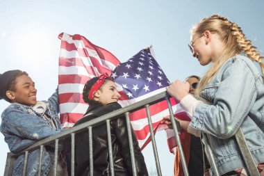Amerikan bayrağı sallayarak gençler