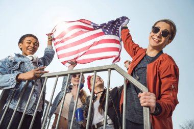Amerikan bayrağı sallayarak gençler