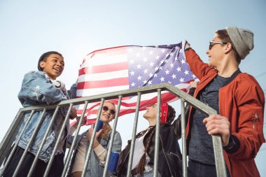 Amerikan bayrağı sallayarak gençler