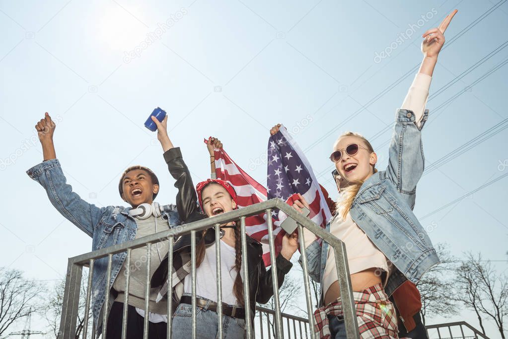 teenagers waving american flag