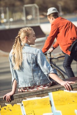 girl resting at skateboard park clipart