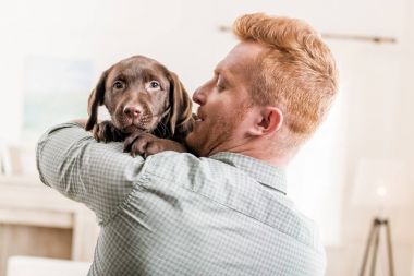Yavru köpek tutan adam