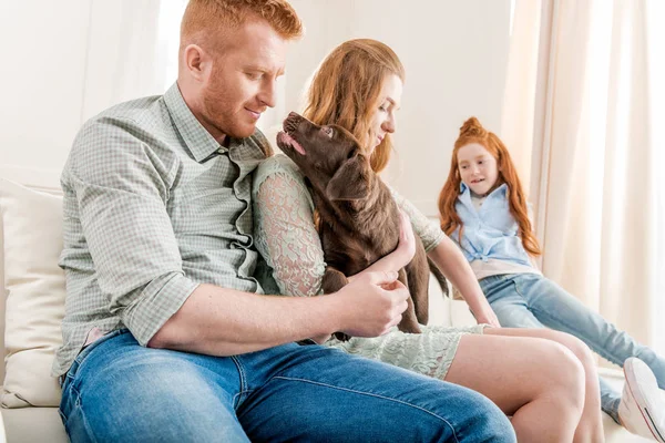 Família brincando com filhote de cachorro — Fotografia de Stock