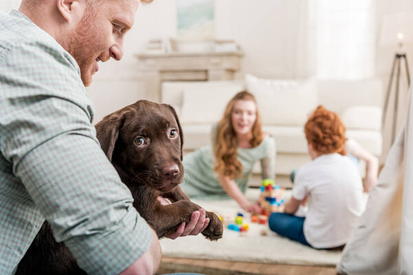 father holding puppy