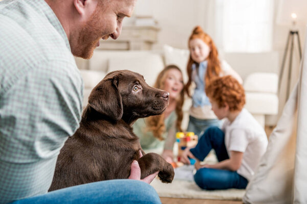 father holding puppy