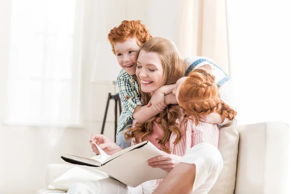Mother with kids reading book — Stock Photo, Image