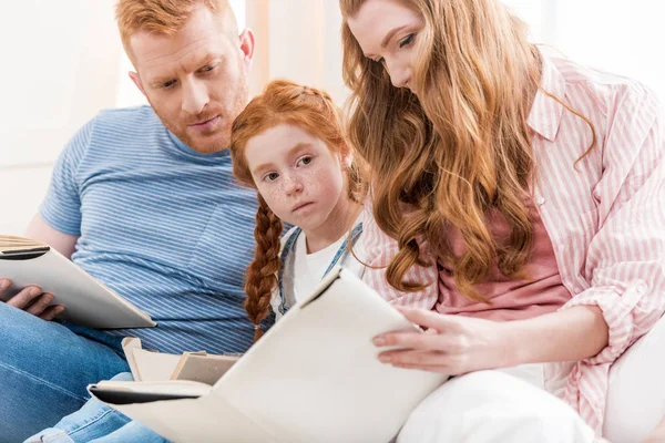 Föräldrar med dotter läsa böcker — Stockfoto