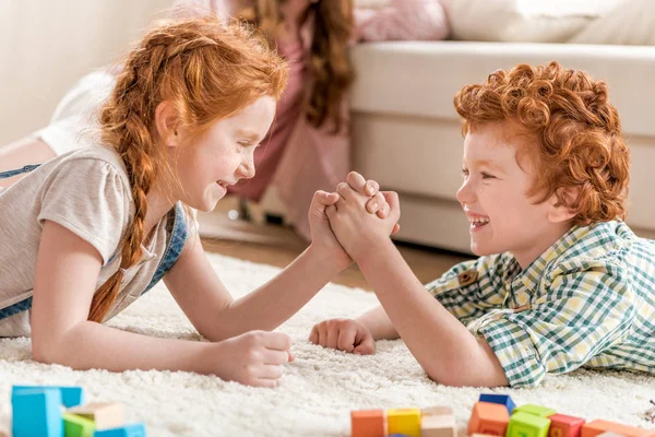 Brother playing arm wrestling with sister — Stock Photo, Image